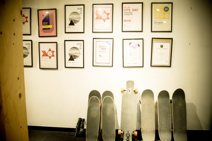 ウェブ制作で受賞した賞状の数々。その下にはスタッフが使っているスケートボードが置かれている